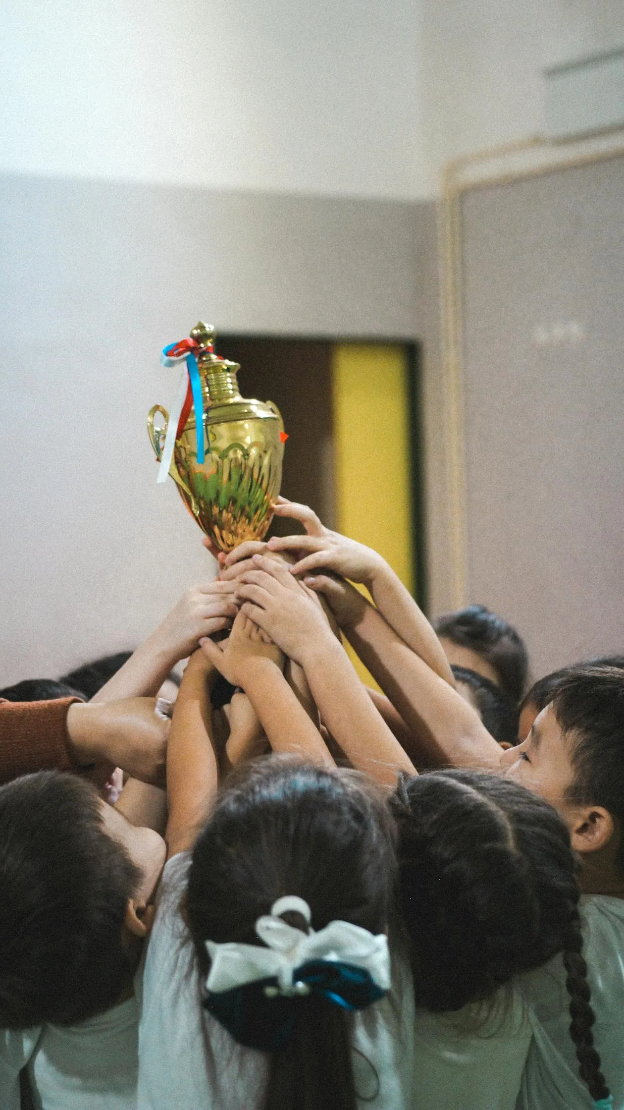 Anak-anak memegang piala bersama